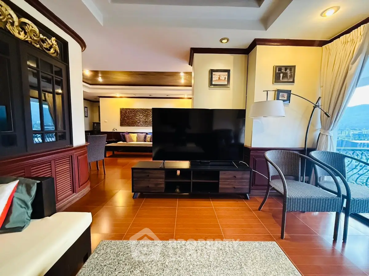 Spacious living room with modern decor and large TV, featuring elegant lighting and mountain views.