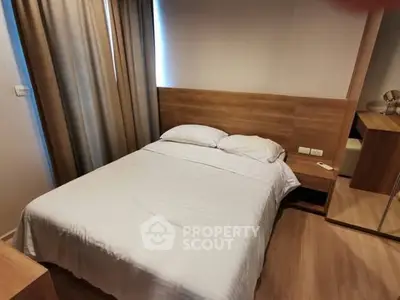 Cozy bedroom with wooden accents and natural light, perfect for relaxation.