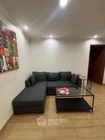 Modern living room with stylish gray sectional sofa and contemporary art on the wall.