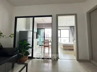 Modern apartment interior with open living space and bedroom view, featuring sleek design and natural light.