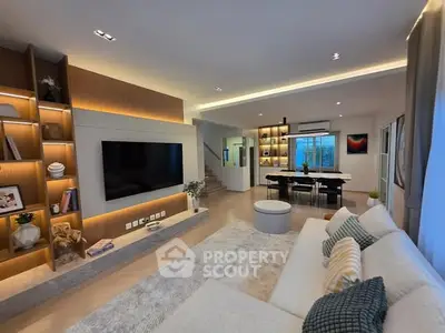 Spacious modern living room with elegant decor and large TV, perfect for family gatherings.