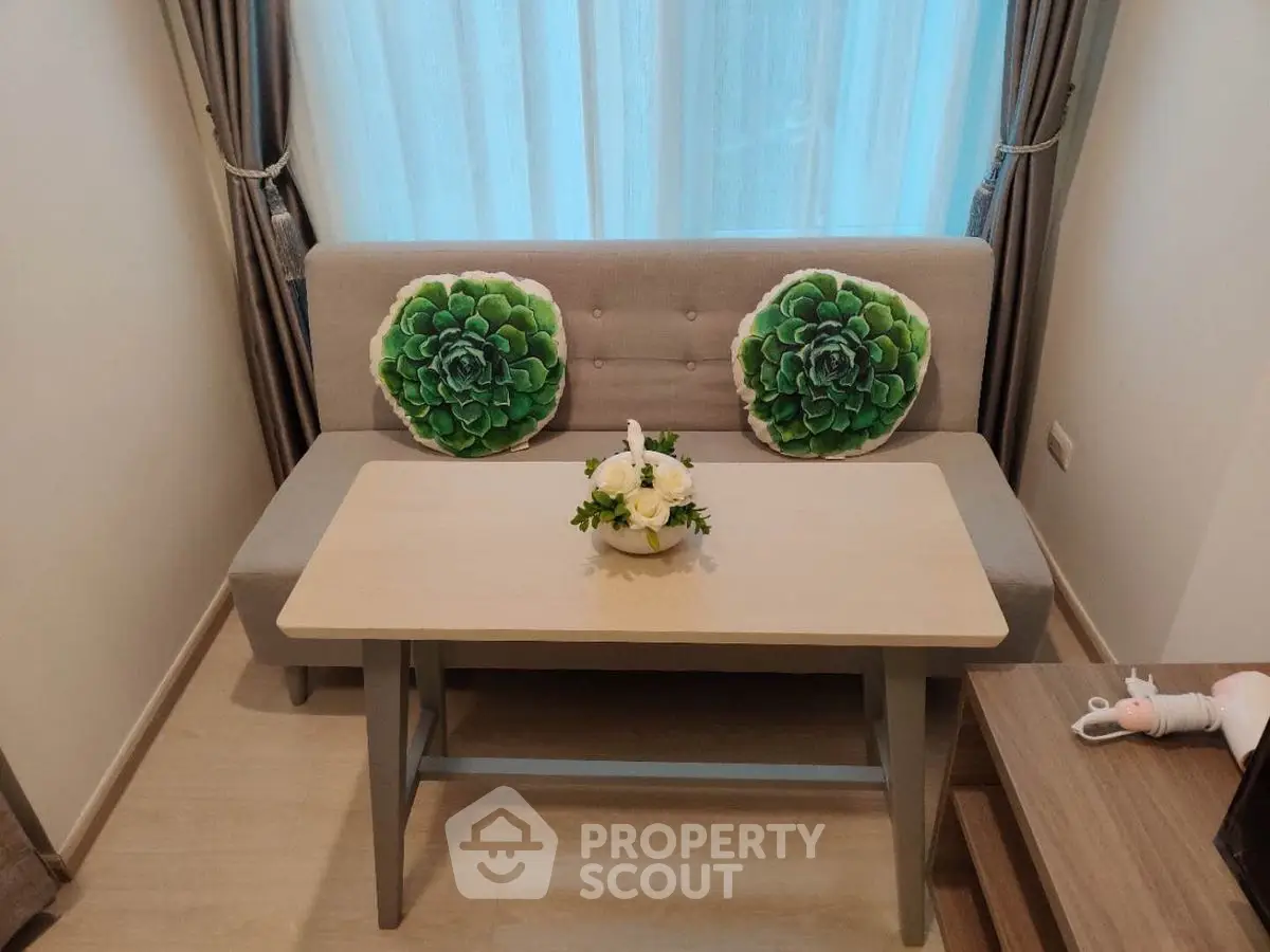 Cozy living room with stylish sofa and decorative cushions, perfect for relaxation.