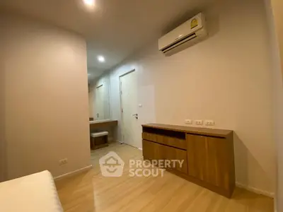 Modern minimalist bedroom with wooden flooring and air conditioning