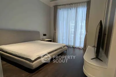 Spacious modern bedroom with large window and sleek furnishings