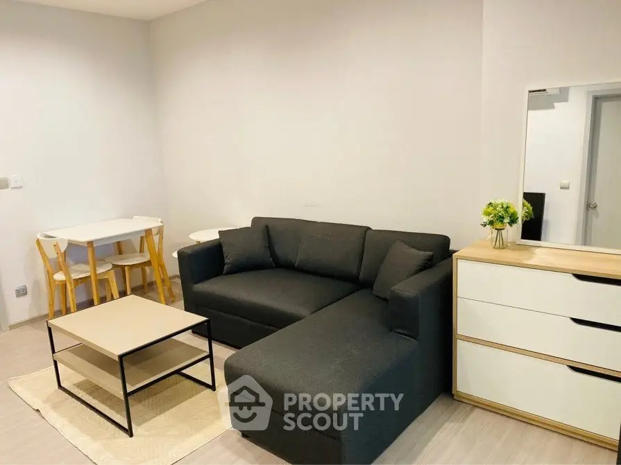 Cozy living room with modern sofa and dining area in a stylish apartment.