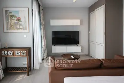 Stylish living room with modern decor and large TV, perfect for relaxation.