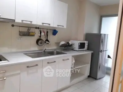Modern kitchen with sleek white cabinets and stainless steel appliances