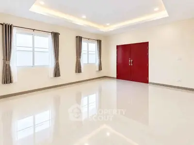 Spacious empty room with glossy tiled floor and red double doors