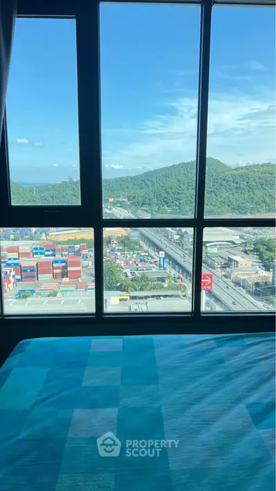 Stunning mountain and city view from a high-rise bedroom window