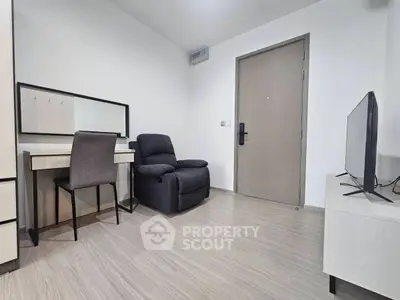 Modern apartment interior with sleek furniture and neutral tones, featuring a cozy armchair and a stylish desk.