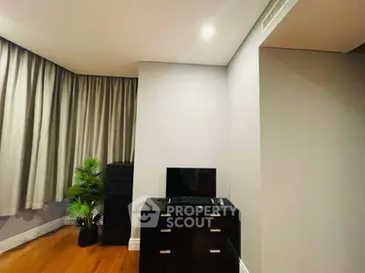 Modern bedroom corner with TV, dresser, and stylish decor