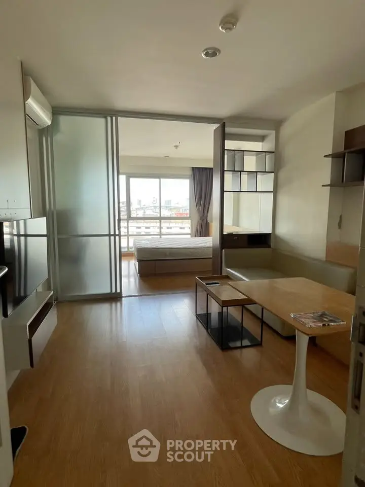 Modern apartment with open layout and city view, featuring sleek furniture and natural light.