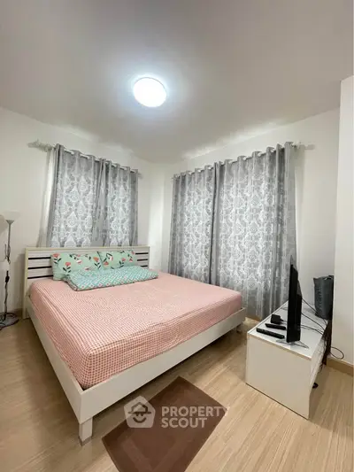 Cozy bedroom with stylish decor and ample natural light, perfect for relaxation.