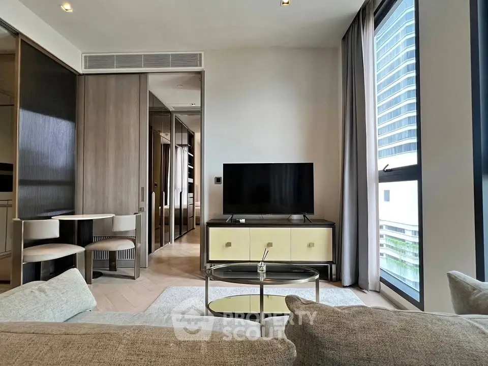 Modern living room with sleek furniture and large window view in luxury apartment.