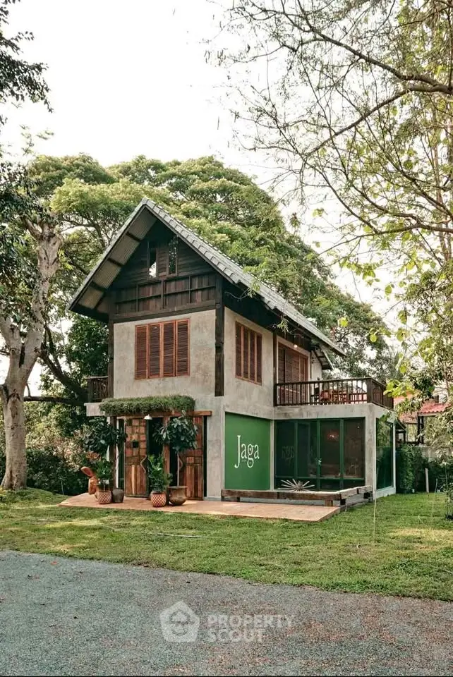 Charming two-story house with rustic design and lush greenery, perfect for serene living.