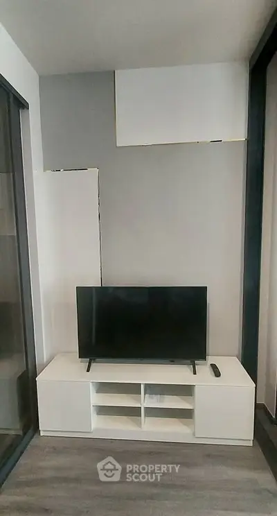Modern living room with sleek TV stand and flat-screen TV, perfect for entertainment setup.
