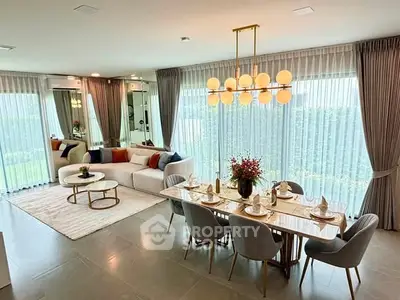 Luxurious open-plan living and dining area with elegant decor and large windows.
