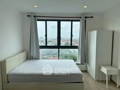 Spacious bedroom with large window offering stunning city views, featuring a comfortable bed and minimalist furniture.