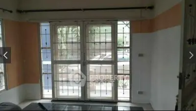 Spacious living room with large windows and security bars, offering natural light and a view of the outdoors.