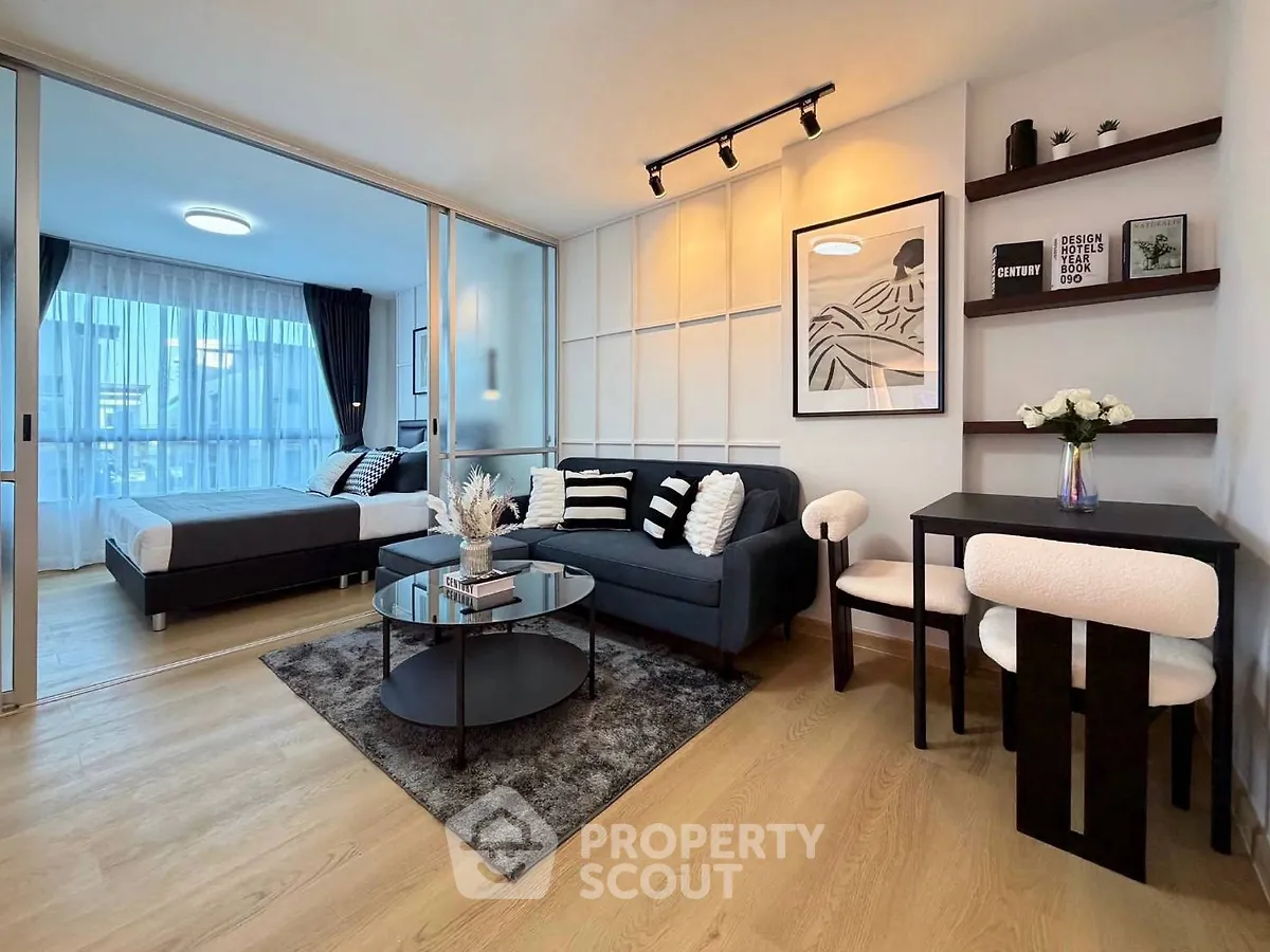 Modern open-plan living room with stylish decor and cozy bedroom area