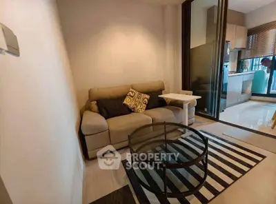 Cozy living room with modern decor and open kitchen layout in a stylish apartment.