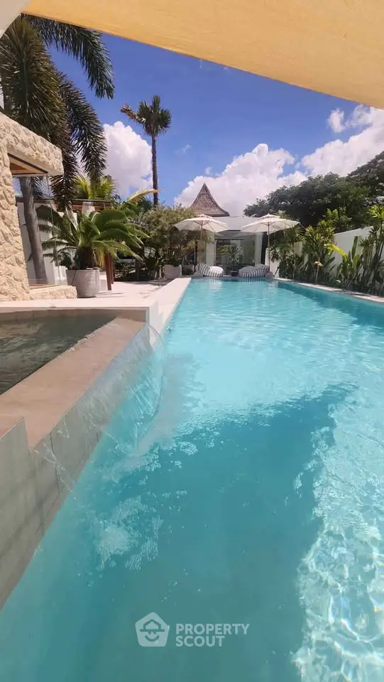 Luxurious tropical villa with stunning pool and lush greenery, perfect for relaxation and leisure.