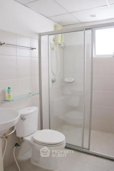 Modern bathroom with glass shower enclosure and sleek fixtures.