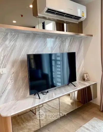 Modern living room with sleek TV setup and air conditioning, featuring elegant marble accents.