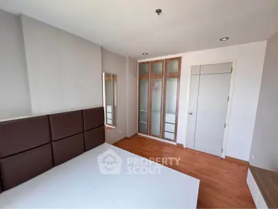 Spacious bedroom with wooden flooring and modern closet design