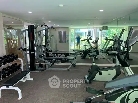 Modern gym with state-of-the-art equipment and mirrored walls in a residential building.
