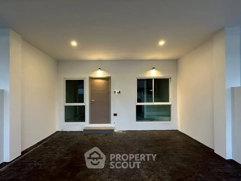 Modern minimalist house entrance with sleek lighting and clean design.