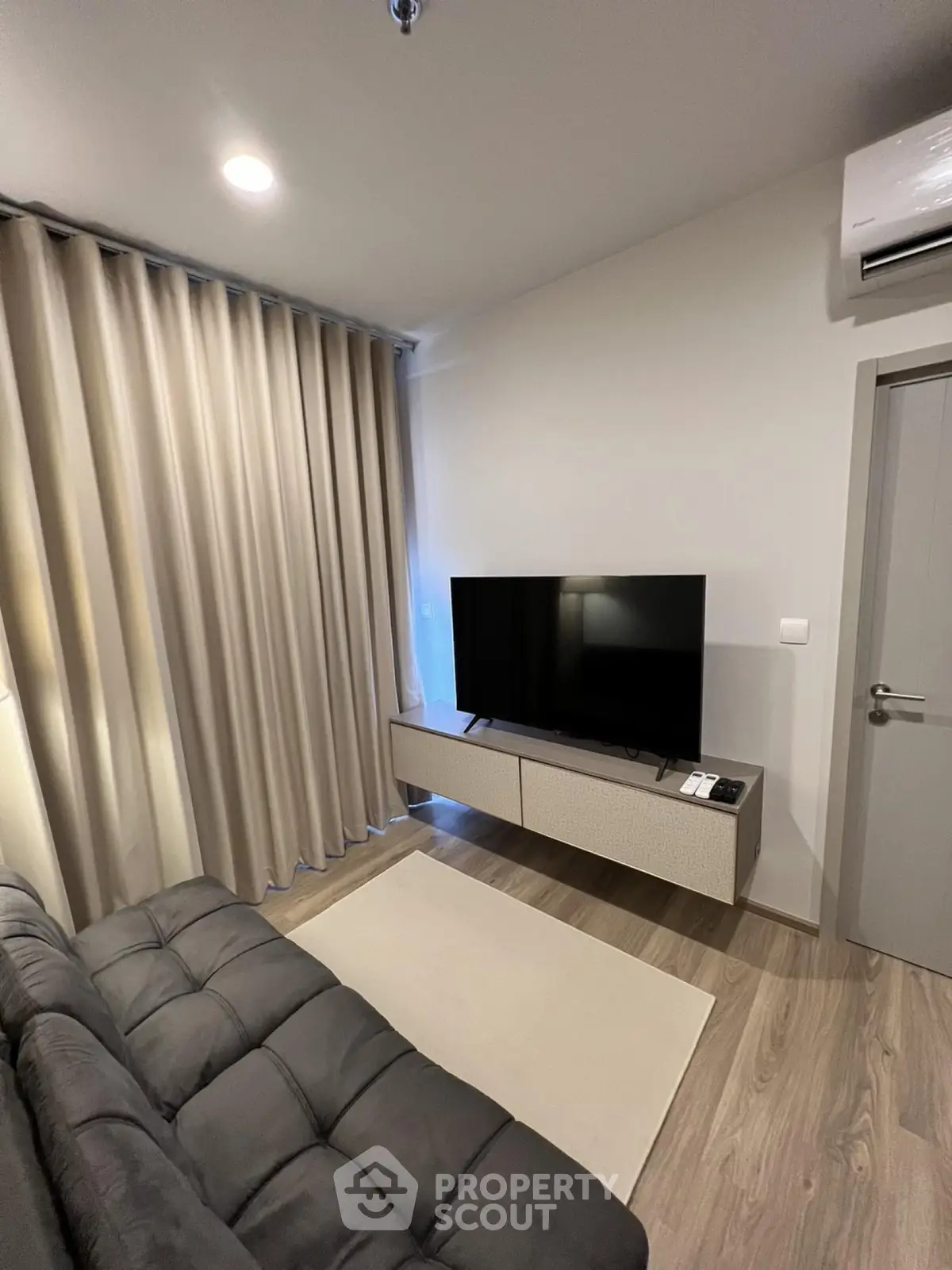 Modern living room with sleek TV setup and cozy sofa, perfect for relaxation.