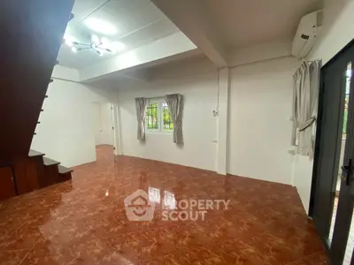 Spacious living room with tiled flooring and natural light, perfect for modern living.