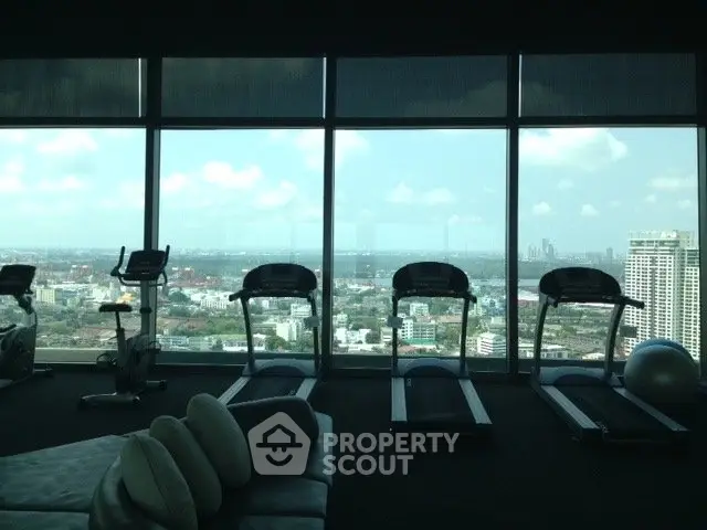 Luxurious high-rise gym with panoramic city views and modern fitness equipment.