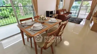 Spacious living room with dining area and garden view, featuring elegant furniture and natural light.