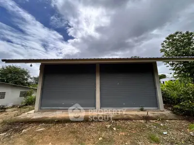 Modern storage unit with dual roller doors and lush surroundings, perfect for secure storage solutions.