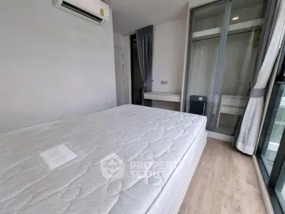 Modern bedroom with large window and air conditioning in a stylish apartment.