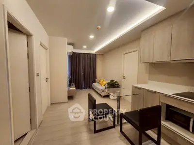 Modern living room with sleek kitchen and cozy seating area in a stylish apartment.