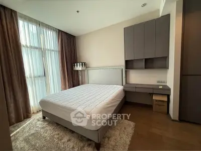 Modern bedroom with large window and stylish furniture in a cozy apartment.