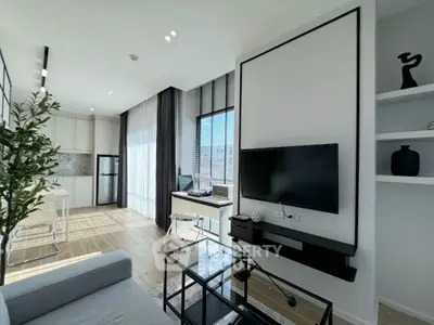 Modern living room with sleek design and open kitchen layout, featuring stylish decor and natural light.