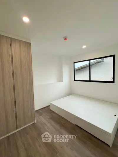 Modern minimalist bedroom with wooden flooring and built-in wardrobe