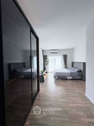 Spacious modern bedroom with large windows and sleek flooring