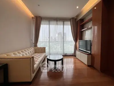 Modern living room with city view, featuring elegant sofa and entertainment center.