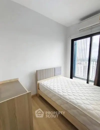 Modern bedroom with minimalist design and large window offering city view.