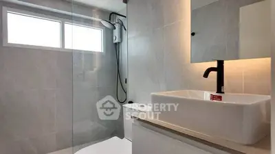 Modern bathroom with sleek fixtures and elegant design, featuring a spacious shower area and stylish vanity.