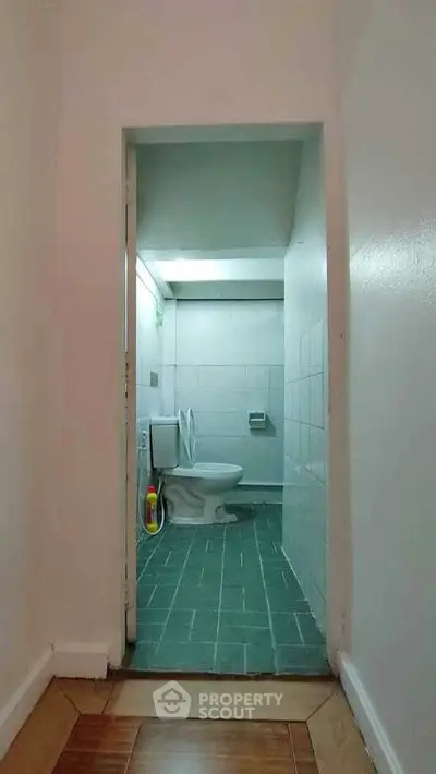 Compact bathroom with tiled flooring and modern toilet fixture.