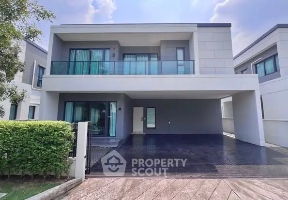 Modern two-story house with spacious driveway and balcony in a serene neighborhood.