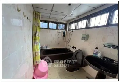Spacious bathroom with bathtub and modern fixtures in a well-lit setting.