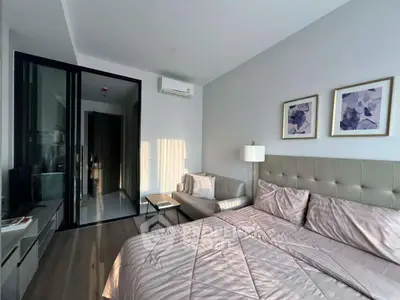 Modern bedroom with stylish decor and natural light, featuring a cozy bed and elegant artwork.