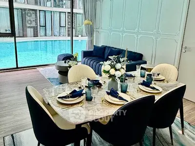 Luxurious living room with pool view and elegant dining setup.